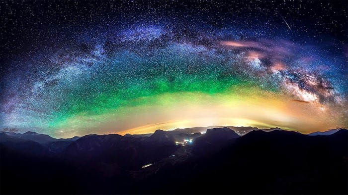 Panoramic view of the Milky Way over mountains at night
