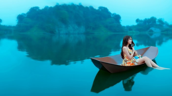 Woman in a boat on a blue lake