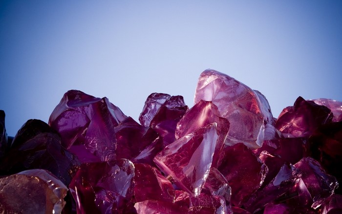 Purple and pink glass shards against a blue sky