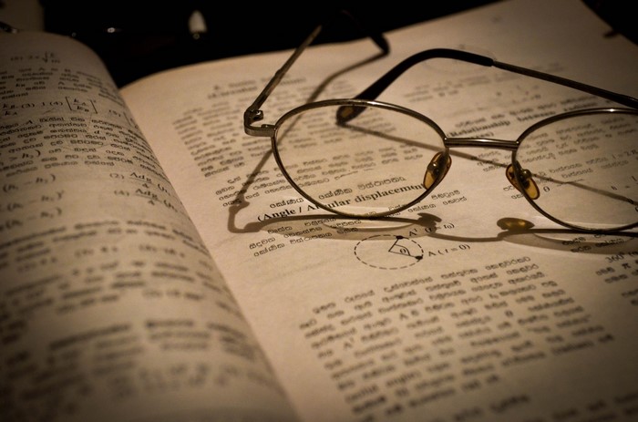 Glasses on an open book with equations