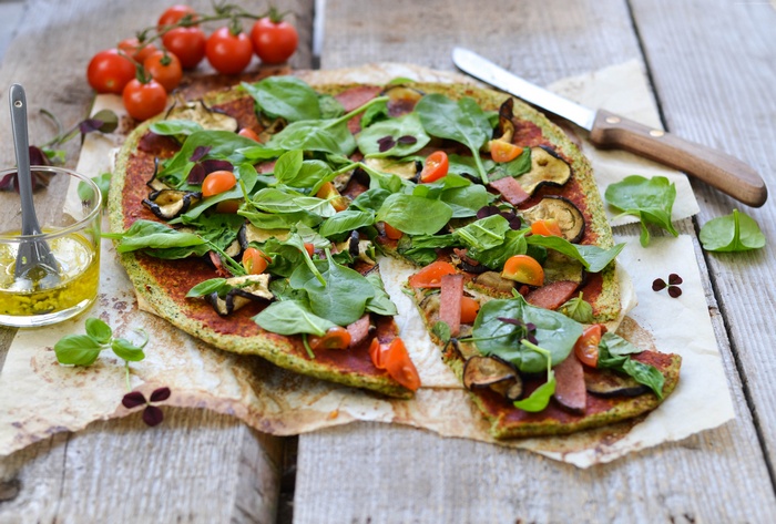 Vegetarian pizza with spinach, tomatoes, and eggplant