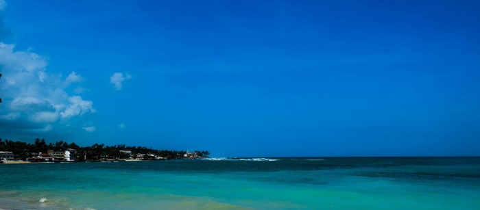 Turquoise ocean with a distant coastline under a bright blue sky