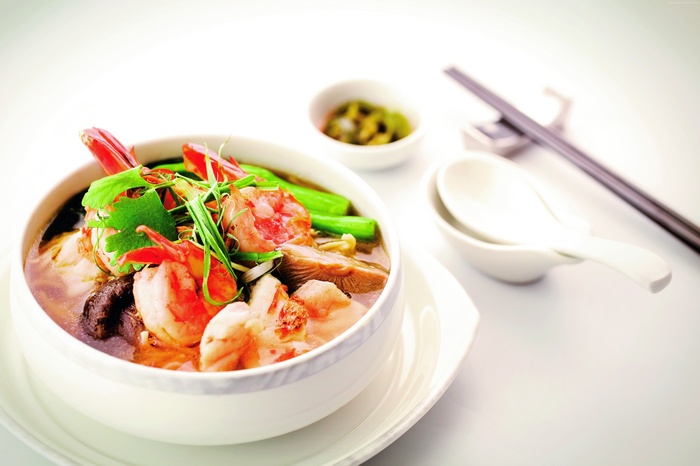 Shrimp and mushroom soup with chopsticks and spoons