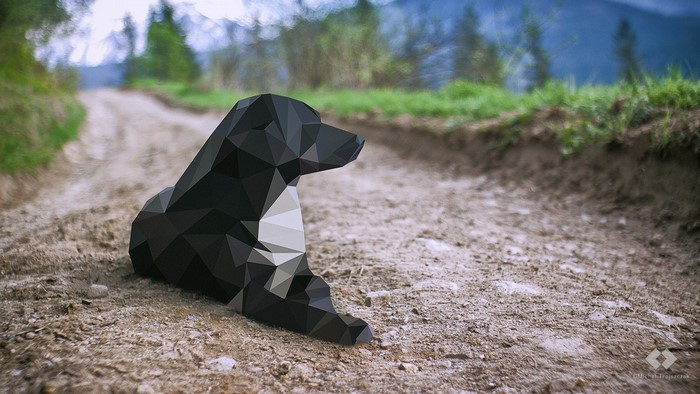Low poly black dog sitting on a dirt road