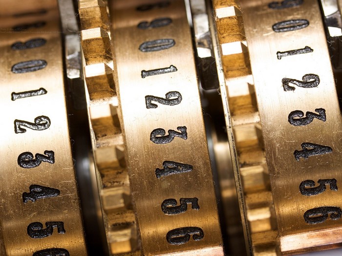 Close-up of brass numbering wheels on a mechanical device