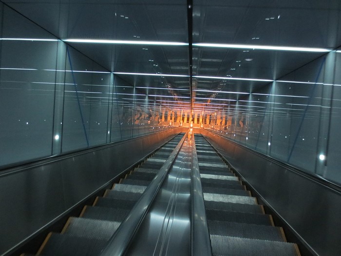 Escalator in a modern tunnel with reflective walls