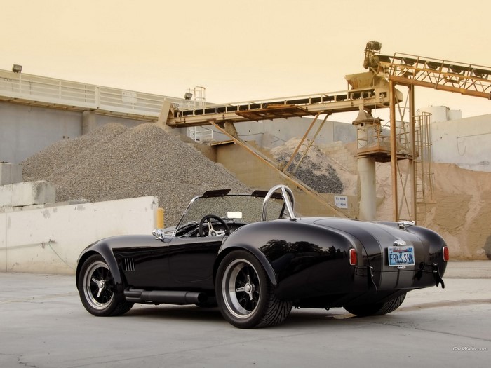 Black Shelby Cobra convertible parked at a gravel quarry