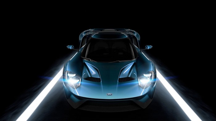 Blue Ford GT sports car with headlights on