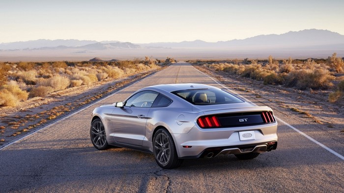 Silver Ford Mustang GT driving on a desert road