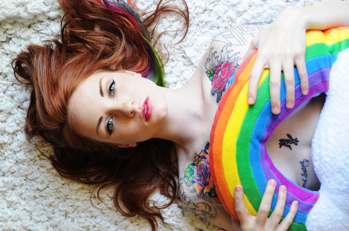 Woman with rainbow pillow and tattoos