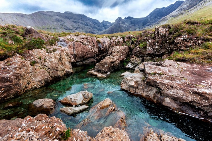 Clear turquoise water flowing over rocks in a mountain valley
