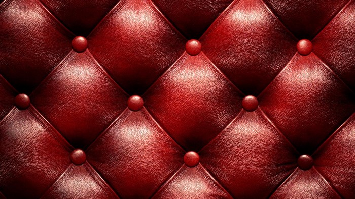 Red tufted leather upholstery close-up