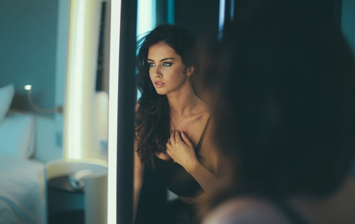 Woman with blue eyes looking in a mirror