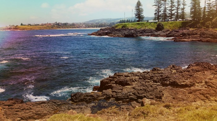 Rocky coastline with ocean and distant town