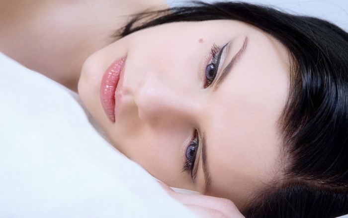 Close-up portrait of a woman with black hair and blue eyes