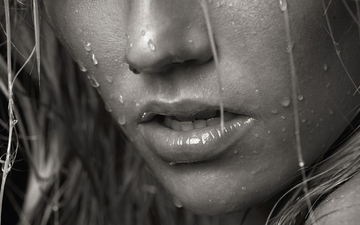 Monochrome close-up of a woman's face with water droplets