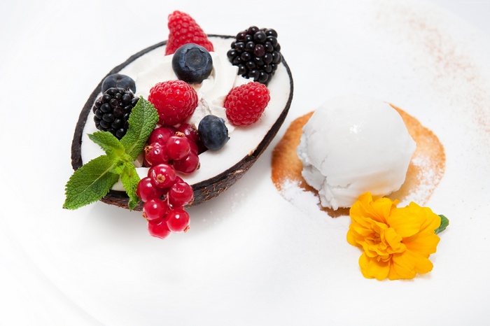 Coconut shell filled with berries and ice cream