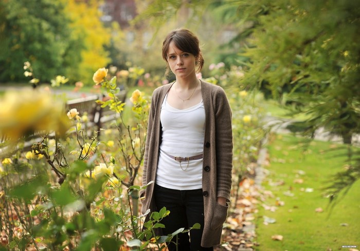 Claire Foy in a park with yellow roses
