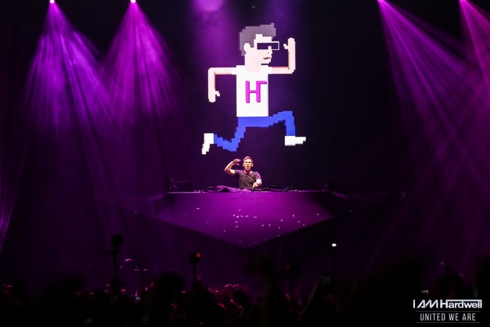 DJ Hardwell performing on stage with pixelated character graphic