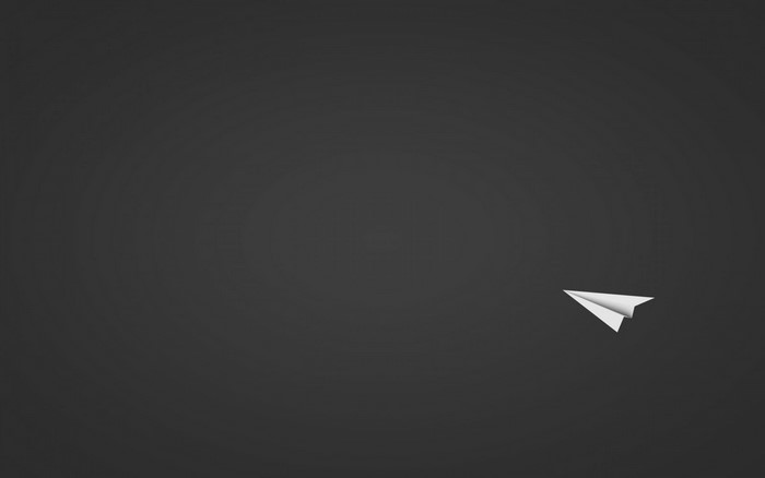 A white paper airplane flies across a dark gray background.