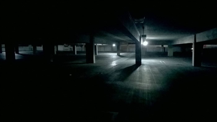 Dark empty parking garage at night with lights