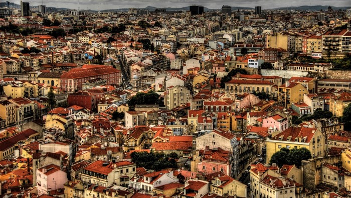 Aerial view of a dense European city with red-tiled roofs