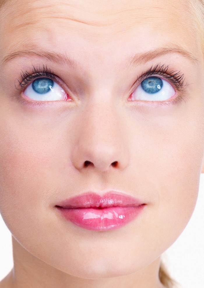 Close up of a young woman's face with blue eyes and pink lips