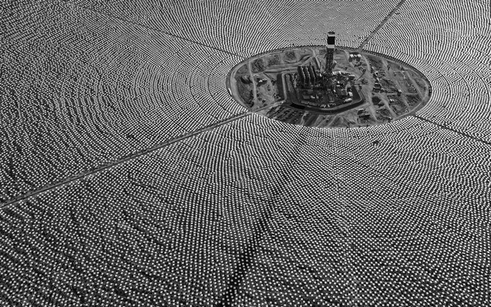 Aerial view of a solar power tower surrounded by heliostats