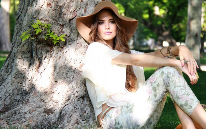 Woman in Hat and Floral Pants Sitting by Tree