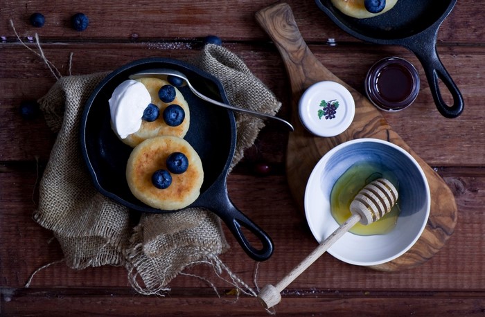 Pancakes with blueberries and cream in a cast iron pan