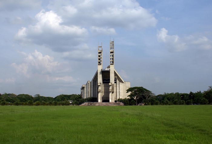 Concrete church with tall towers in a grassy field