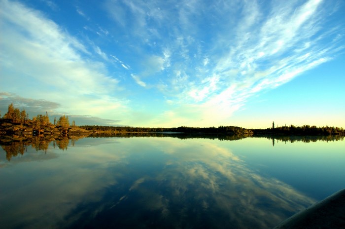 Calm lake reflecting a dramatic sky at sunset