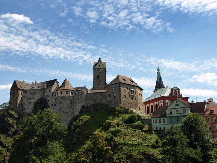 Castle and town on a hill under a cloudy sky