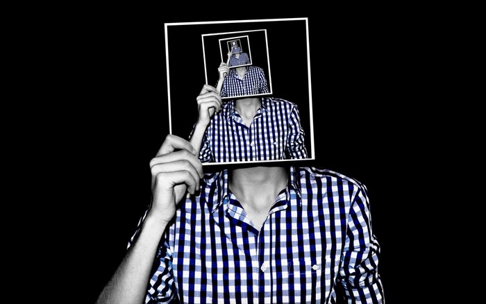 Man holding picture frames with recursive image