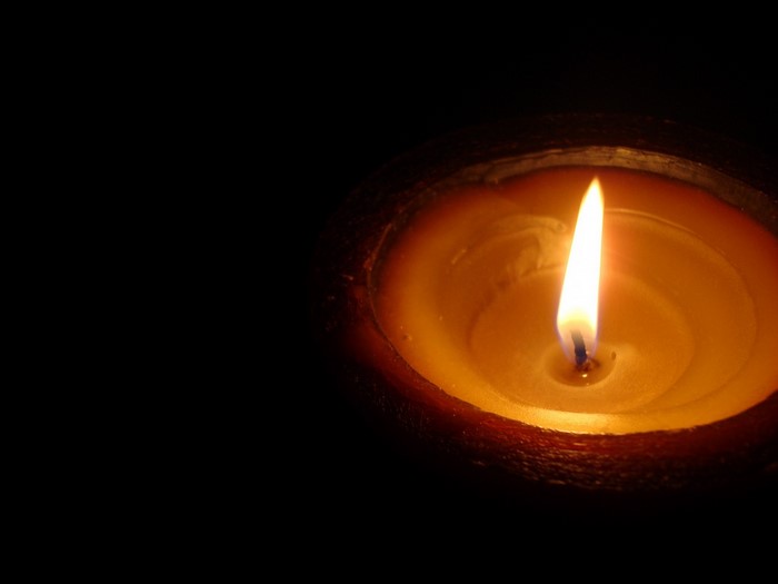 Close-up of a lit candle in darkness