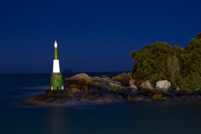 Lighthouse on a rocky island at night