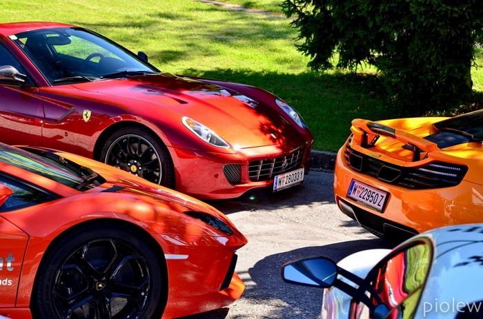 Red Ferrari, Orange McLaren, and Red Lamborghini sports cars
