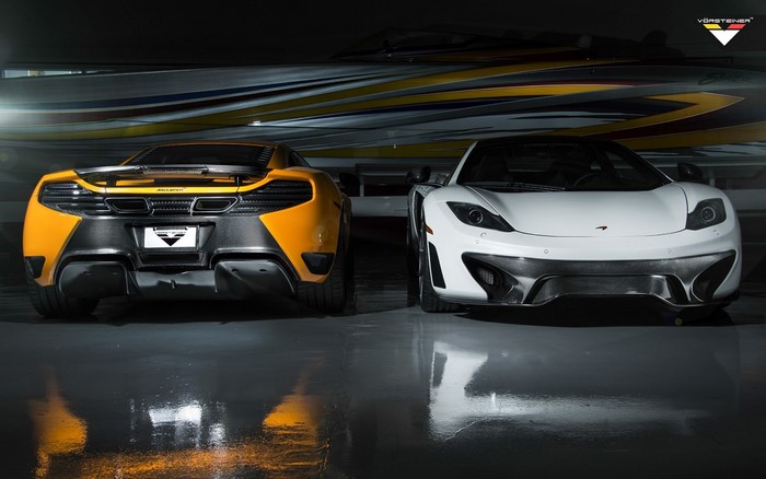 Two McLaren MP4-12C sports cars, one orange and one white