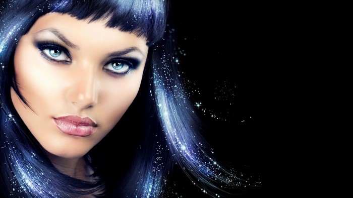 Woman with blue streaks in black hair and sparkling makeup