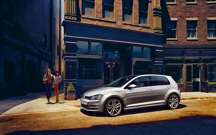 Silver Volkswagen Golf VII parked in front of a building