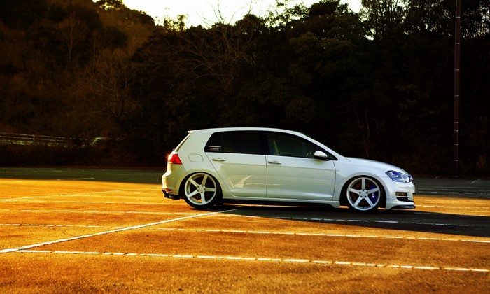 White Volkswagen Golf 7 parked on asphalt