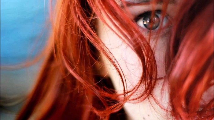 Close-up of a woman with red hair and blue eyes