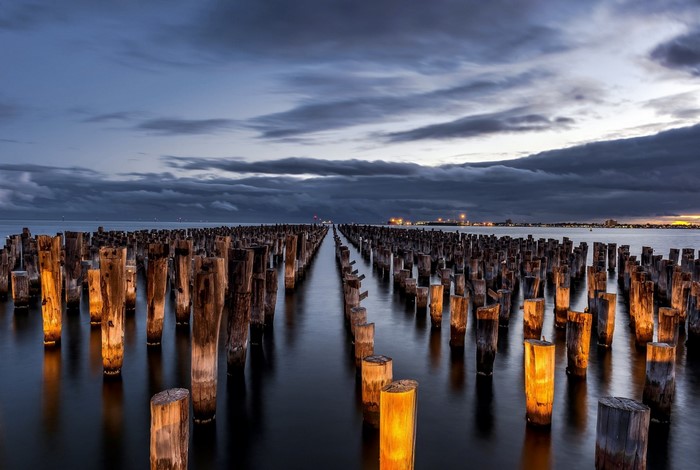 Wooden pier pilings in the ocean at dusk