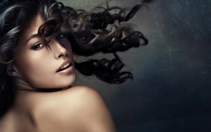 Woman with curly hair looking back