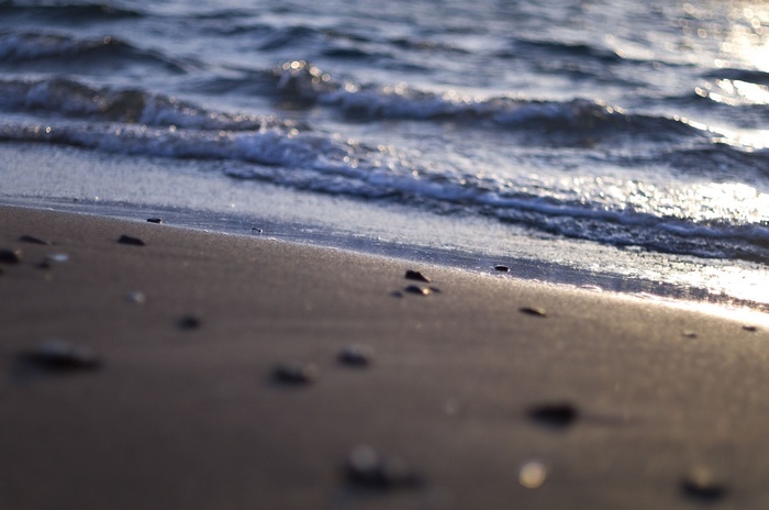 Waves washing over a sandy beach with pebbles