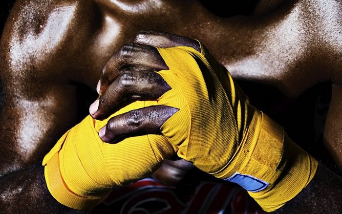 Close up of boxer's hands wrapped in yellow tape