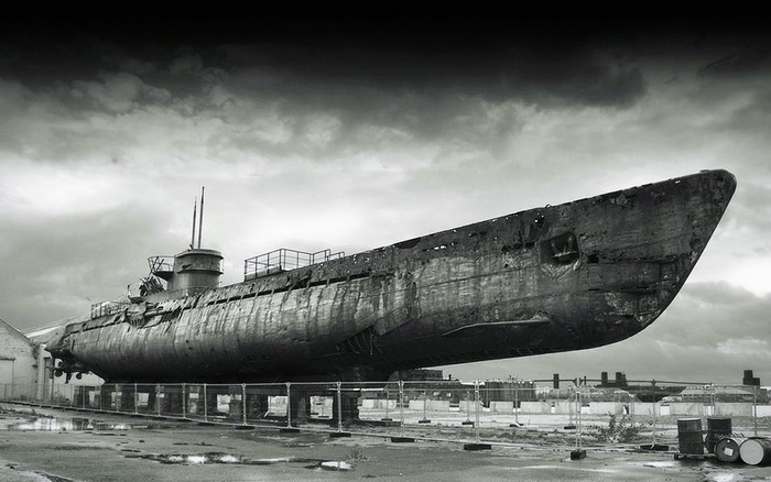 Monochrome image of a derelict submarine on land