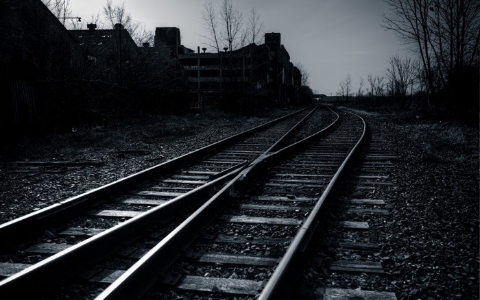 Abandoned railway tracks leading to industrial buildings