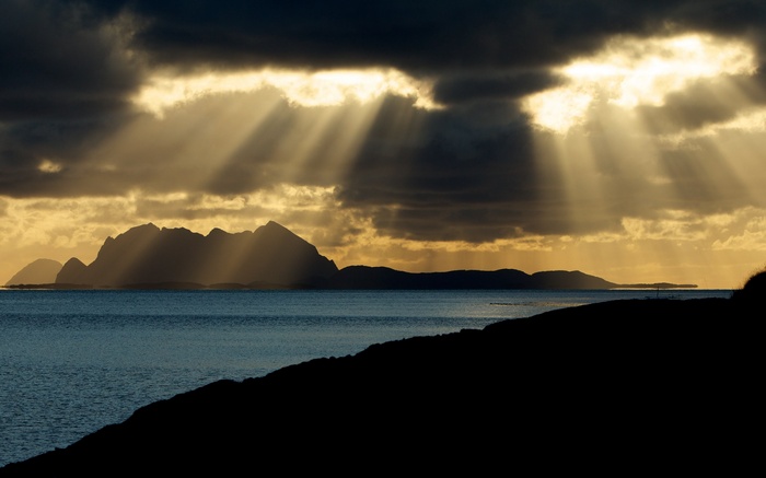 Sunbeams through clouds over islands and sea