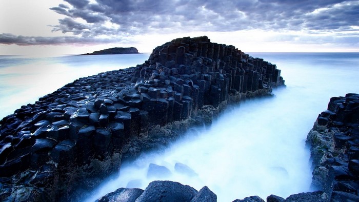 Hexagonal rock formations on the coast with ocean waves